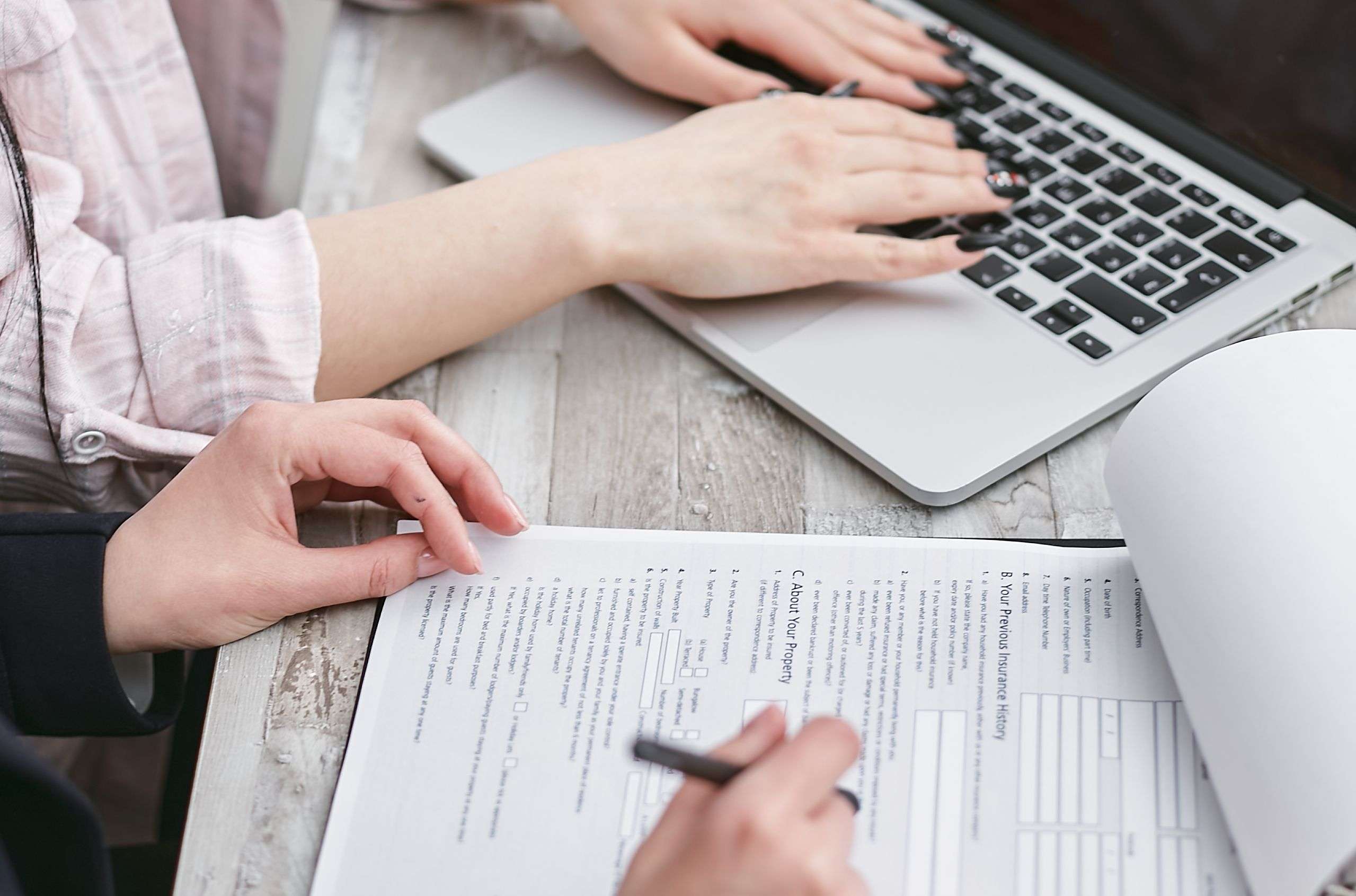 Propietarios revisando documentos, facturas y una calculadora para declarar los ingresos del alquiler vacacional en la Renta.