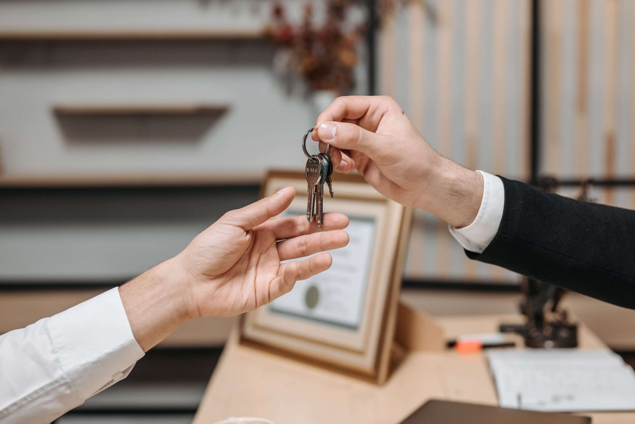 Primer plano de la entrega de llaves de un piso de alquiler vacacional tipo Airbnb sobre el mostrador de recepción en Getafe.